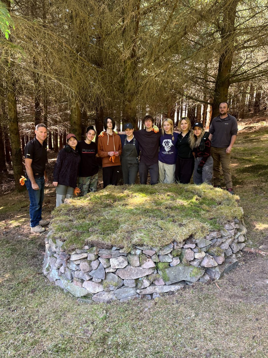 Canadian students standing in front of a dry stone circular table constructed under the direction of experienced dry-stone dyker, Neil Moffat.
